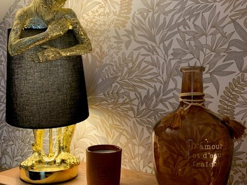 Décor intérieur avec lampe stylisée et objets artisanaux sur un fond floral