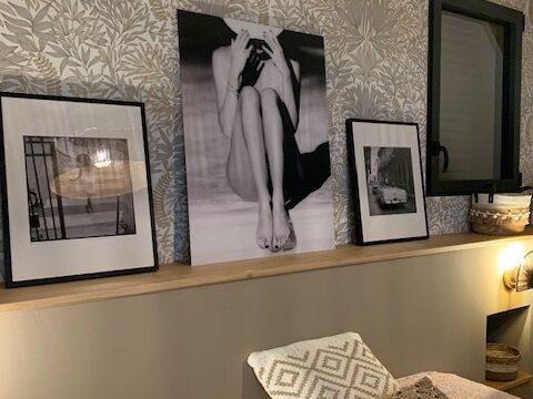 Décor moderne avec œuvres en noir et blanc sur un mur, mettant en valeur un espace chaleureux et stylé.